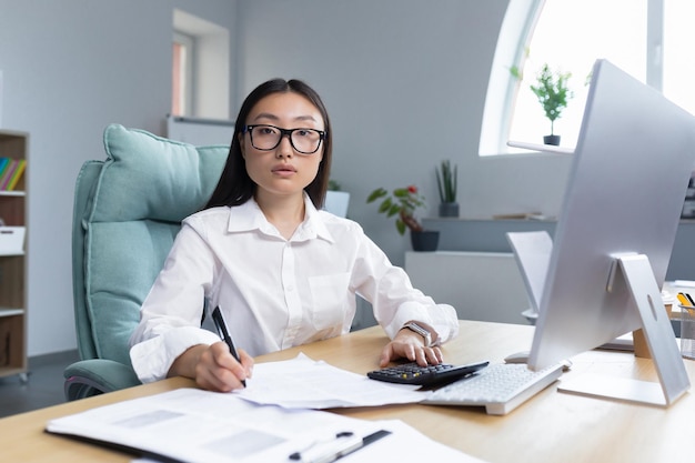 Work with documents portrait of a young beautiful business woman asian accountant works with