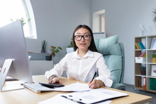 Work with documents portrait of a young beautiful business woman asian accountant works with