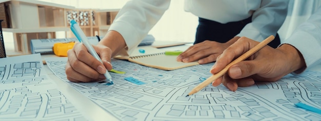 Worker architect and engineer work on real estate construction project oratory planning with cartography and cadastral map of urban town area to guide to construction developer business plan of city