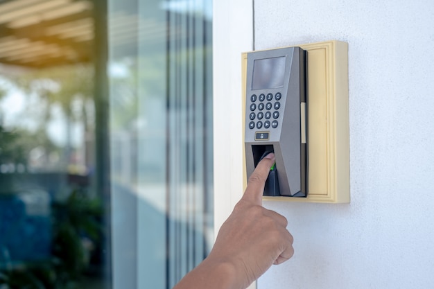 worker are scanning his fingers to open the door or to stamp time to work.