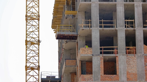 Worker in the building smears up cement on the bricks stirring up concrete