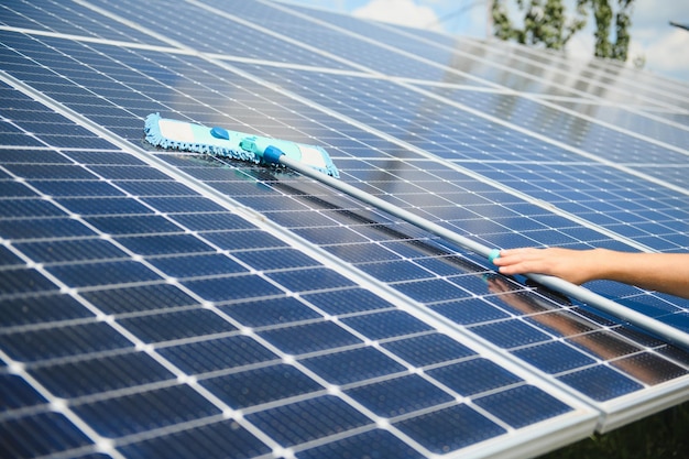 Worker cleaning solar panels after installation outdoors