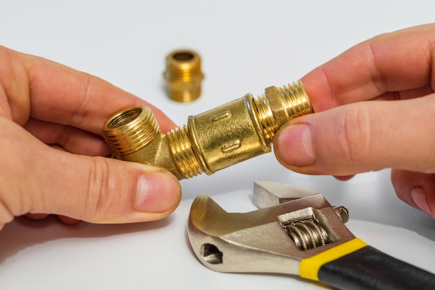 Worker connects plumbing fixtures making repairs with an adjustable wrench