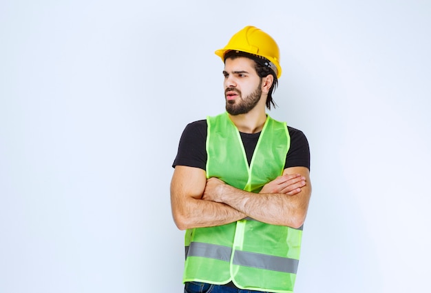 Worker crossing his arms and looks dissatisfied.