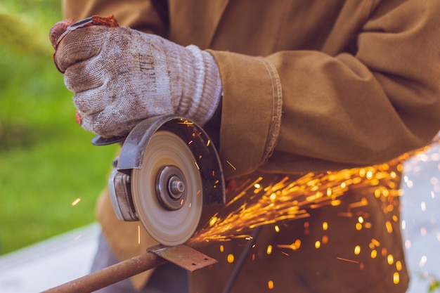 Worker cuts metal grinder