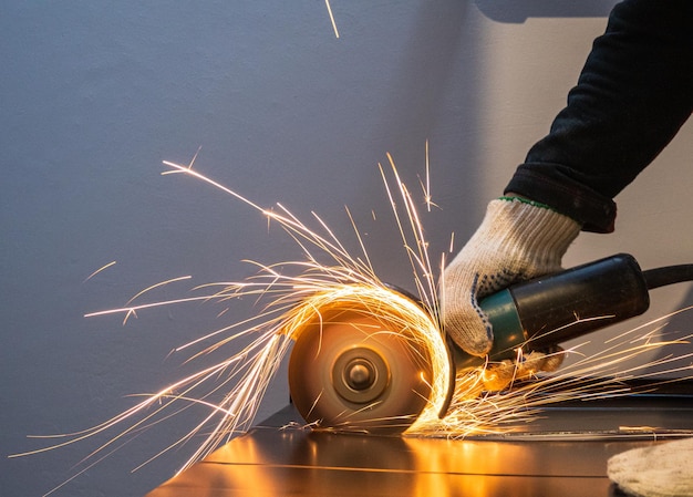 worker cuts metal with an angle grinder