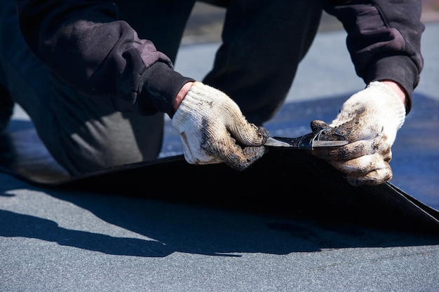 Worker cuts roofing material