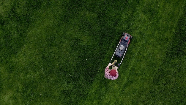 Worker cutting green grass garden Topshot