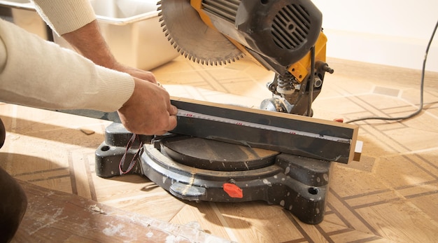 Worker cutting part of furniture with cutting machine