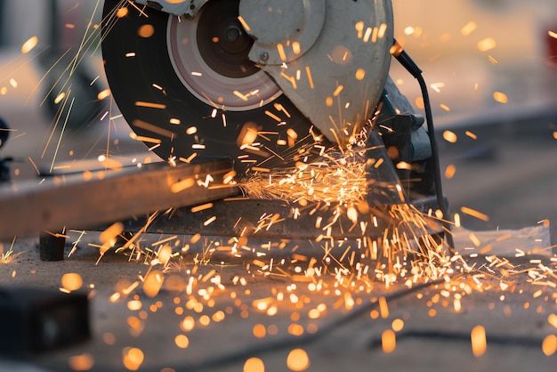 Worker cutting steel rectangular pipe in construction site