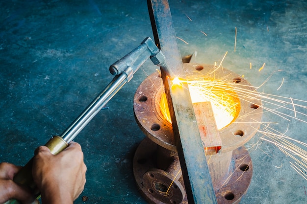 the worker cutting steel with an industrial cutter