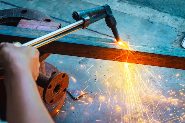 the worker cutting steel with an industrial cutter