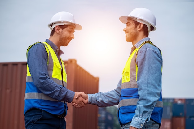 Worker employee shake hand standing container logistic background Business Shake hand or Hand shake concept