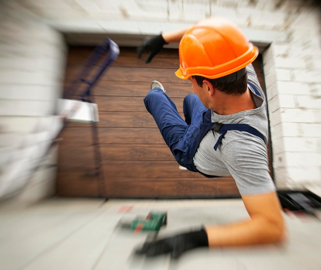 The worker falling down from the ladder while working near the house