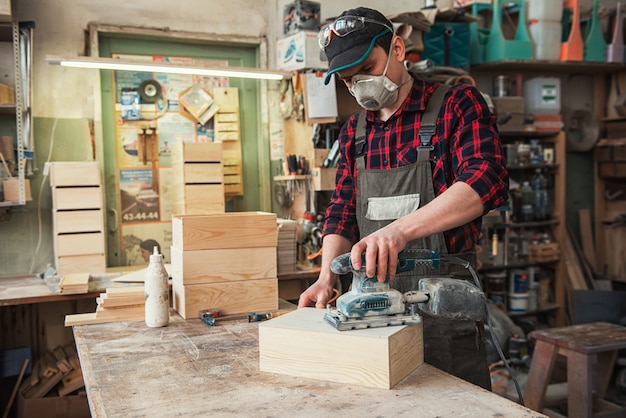 Worker grinds the wood box