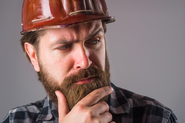 Worker in helmet. Portrait of worker in hardhat. Bearded worker. Close up portrait of tired worker.