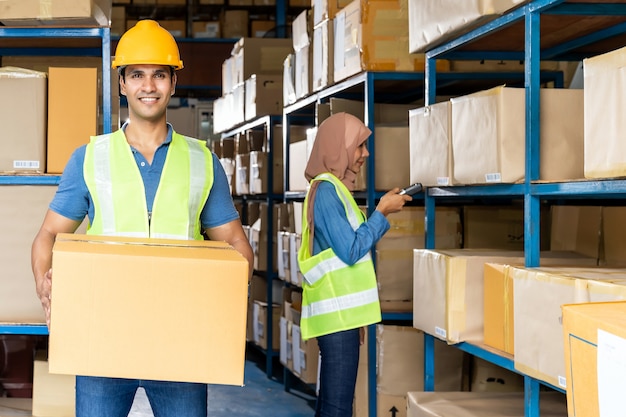 The worker holding a box in the warehouse