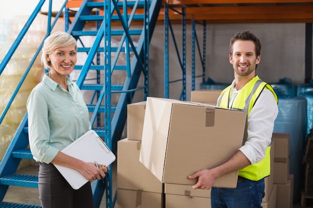 Worker holding box with manager holding clipboard