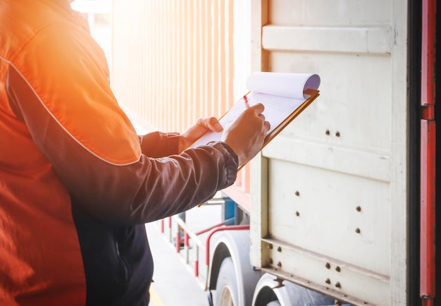 Worker Holding Clipboard is Control Loading Cargo in Shipping Container