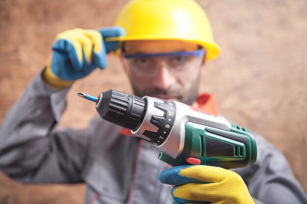 Photo worker holding cordless screwdriver. construction tool