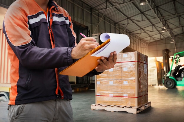 Worker Holds a Clipboard Checking the Loading Cargo Shipment at Distribution Warehouse