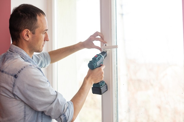 The worker installing and checking window in the house.