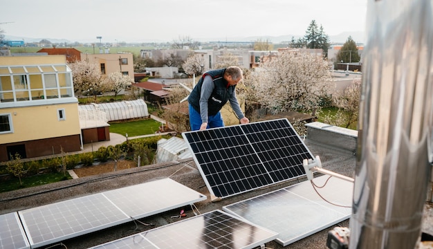 Worker installing new solar panels on roof of family house Eco concept alternative energy