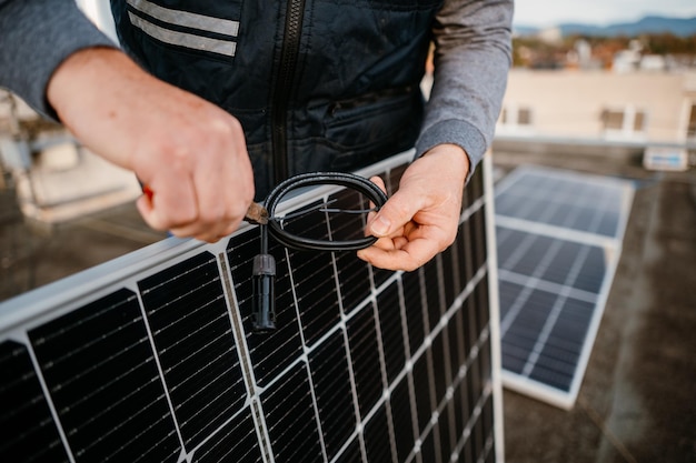 Worker installing new solar panels Worker hold connect cable