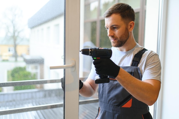 Photo worker installing plastic window indoors