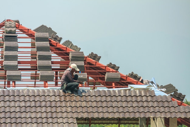 worker installing roof tiles