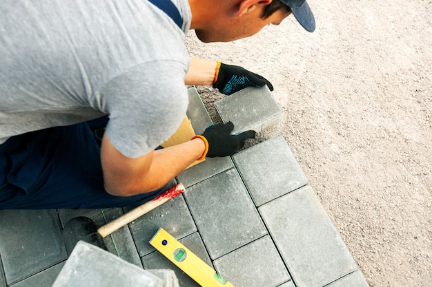 Worker lining paving slabs path