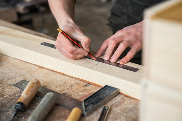 The worker makes measurements of a wooden board