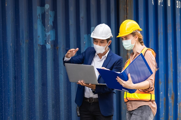 Worker man in surgical mask using a laptop