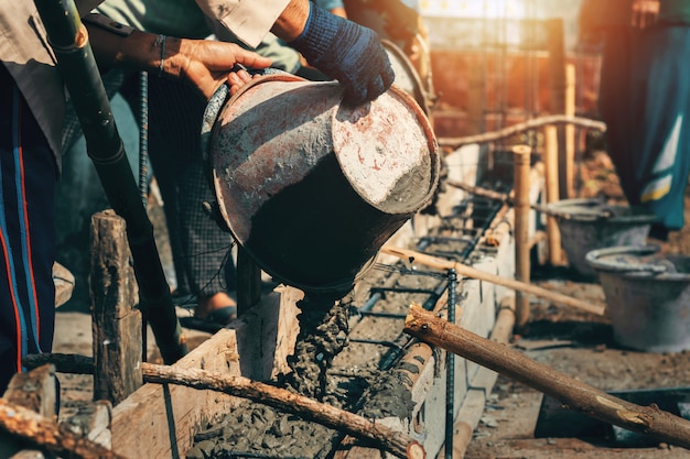 Worker mixing pour construction cement on floor for building house