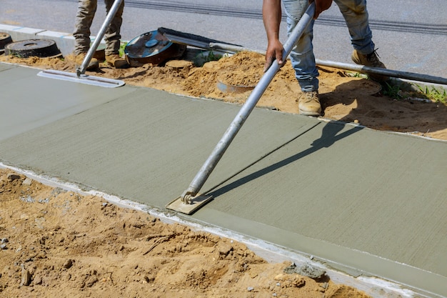 Worker plastering the concrete cement during sidewalk