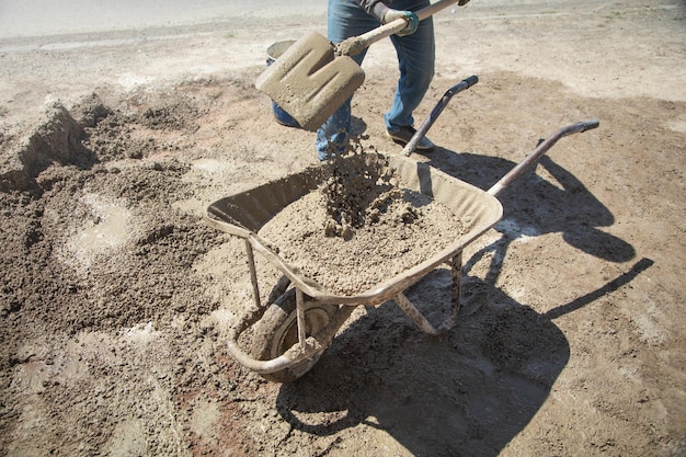 Worker prepare concrete with shovel at construction site