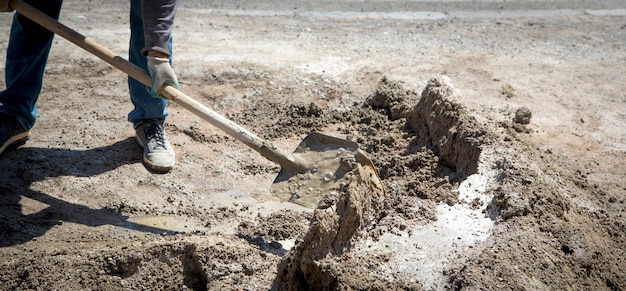 Worker prepare concrete with shovel at construction site