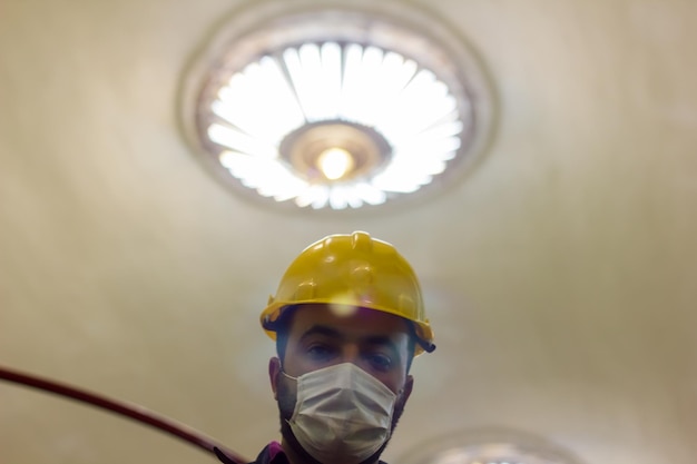 worker in protective mask worker in medical mask construction worker with yellow helmet