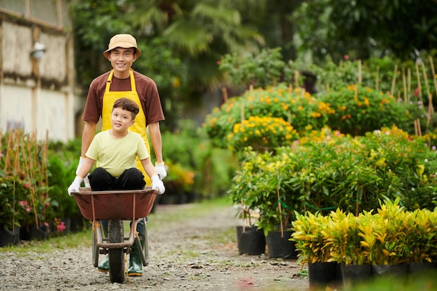 Worker Pushing Wheelbarrow with Son