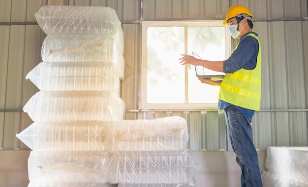 worker and quality inspector in a factory checking number of white plastic bottles in the warehouse