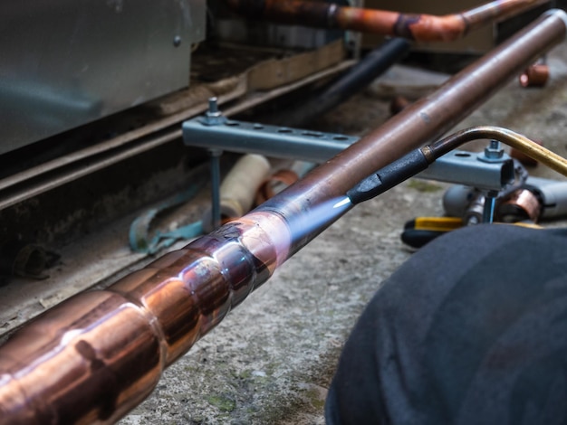 worker soldering a copper pipe