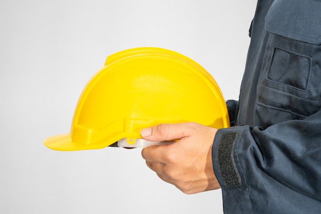 Worker standing in coverall holding hardhat