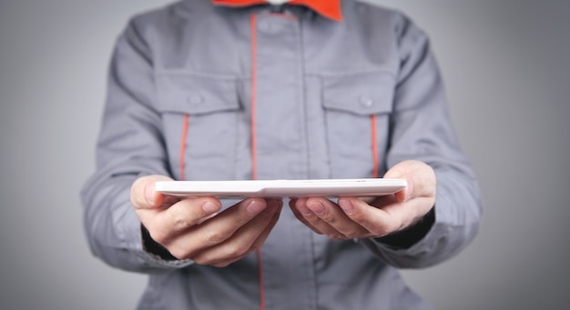 Worker in uniform holding tablet.