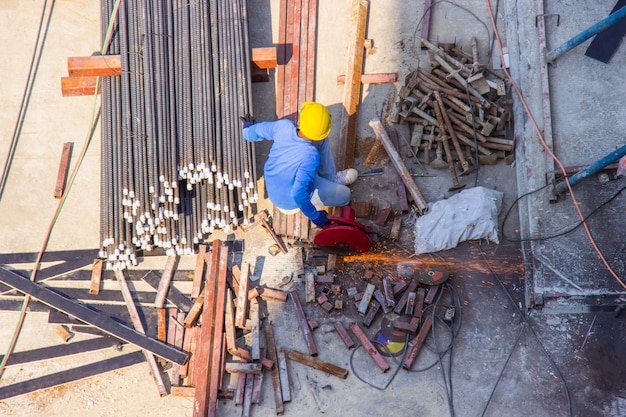 Worker use electric industrial steel cutting machine work in area construction building.