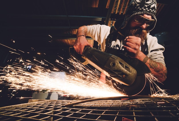 Worker Using Angle Grinder in Factory and throwing sparks