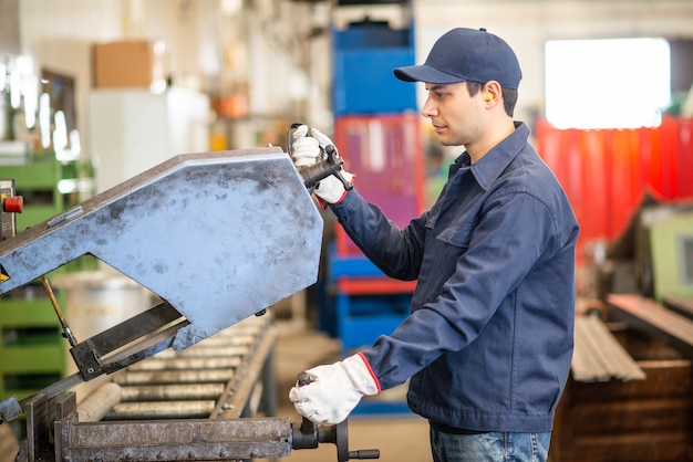 Photo worker using a cropper to cut an iron pipe in a factory