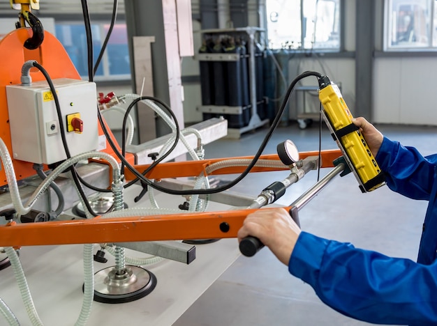 Worker using suction cups for transporting large sheets of metal