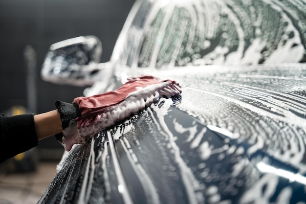 Worker washes the vehicle body with foam and rag