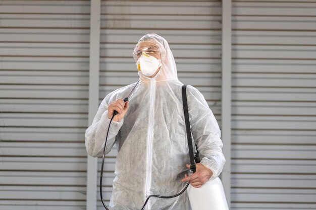 Worker wearing protective suit disinfection gear disinfect surface public place