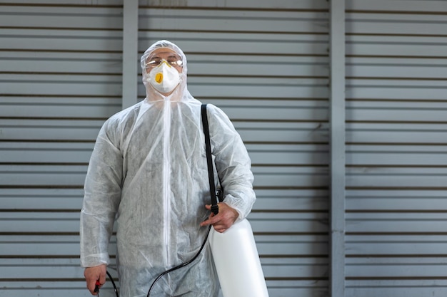 Worker wearing protective suit disinfection gear disinfect surface public place